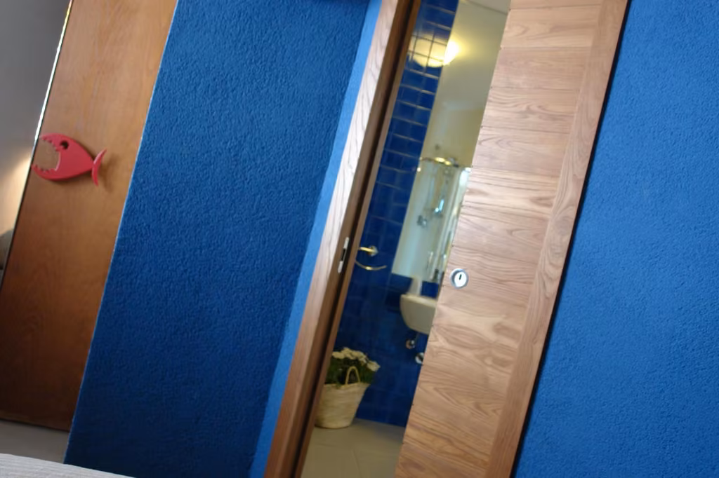 Bagno privato con specchio e parete blu del B&B Sapore di Mare